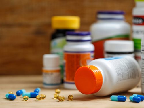 Medicine bottles and tablets on wooden desk